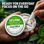 Close-up of hands holding an open can of SYLONI Cool Mint caffeine pouches on fresh mint leaves 